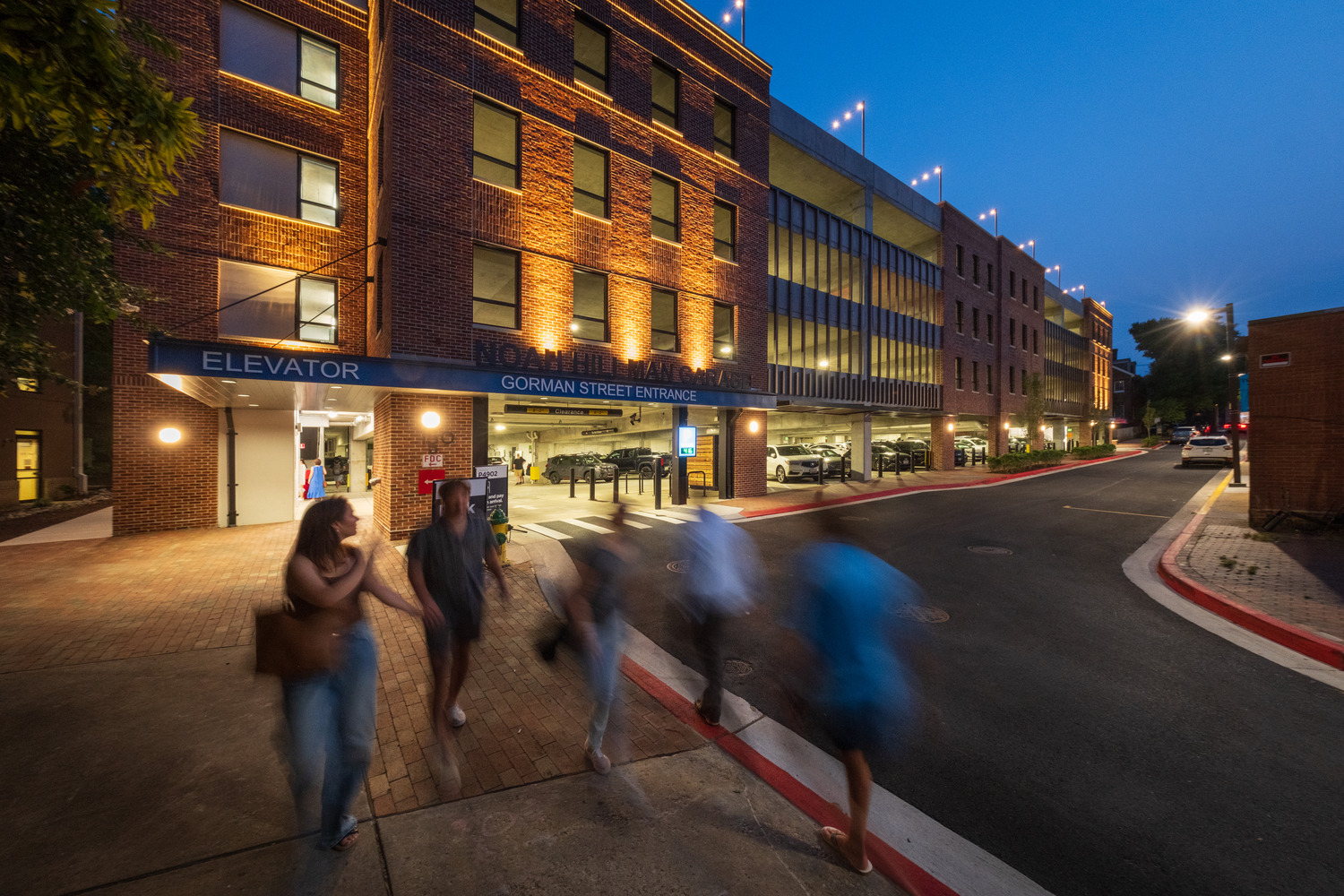 Annapolis Hillman at night with pedestrians People walk on the sidewalk in front of the Hillman garage on a summer evening