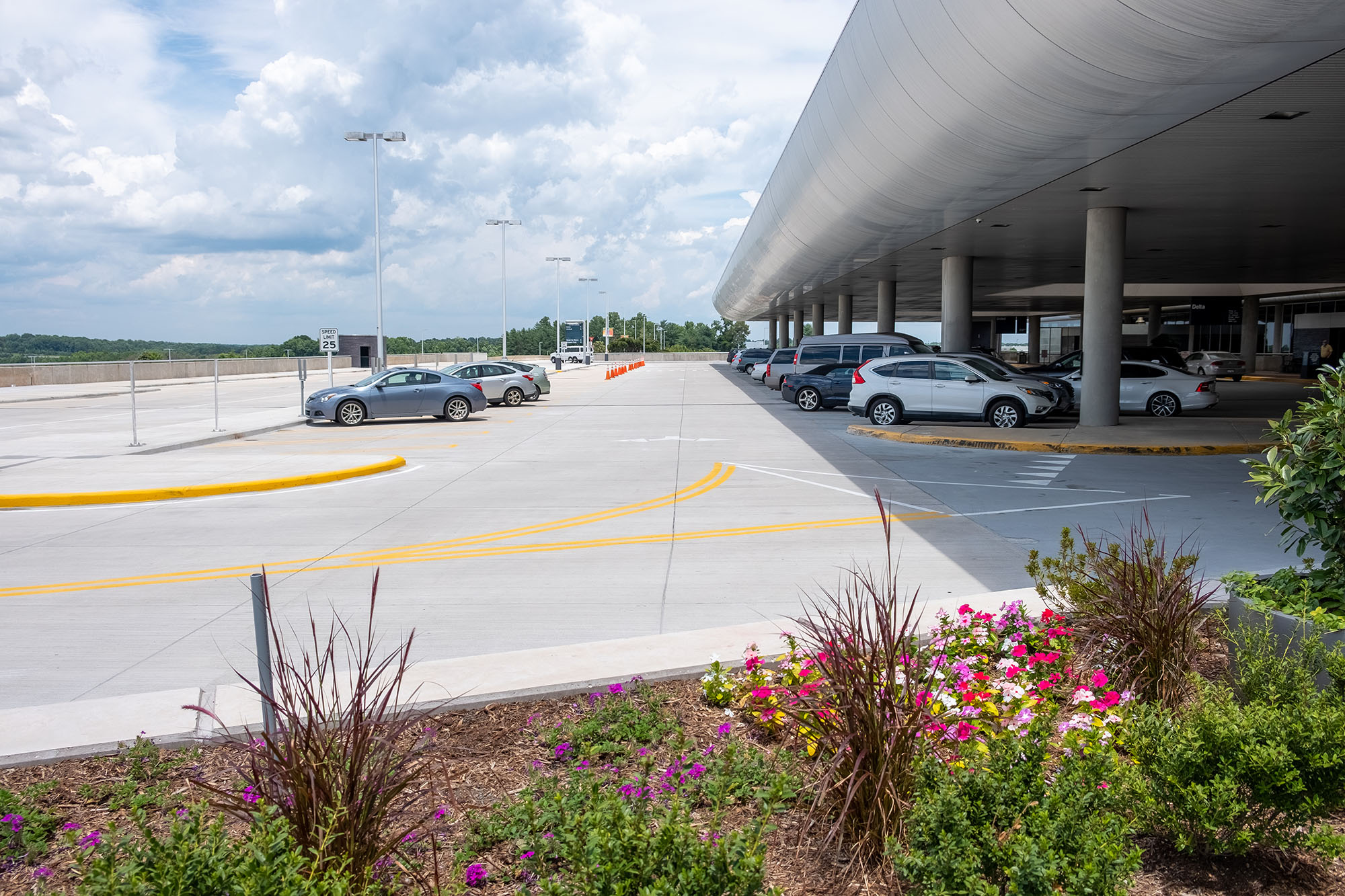 ptia-elevated-roadway Elevated roadway at PTIA with terminal, parked cars, and landscaping in foreground